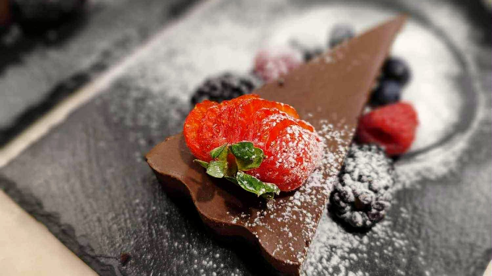 A plated chocolate torte with berries, served at a private dinner cooked by Simon in Spain