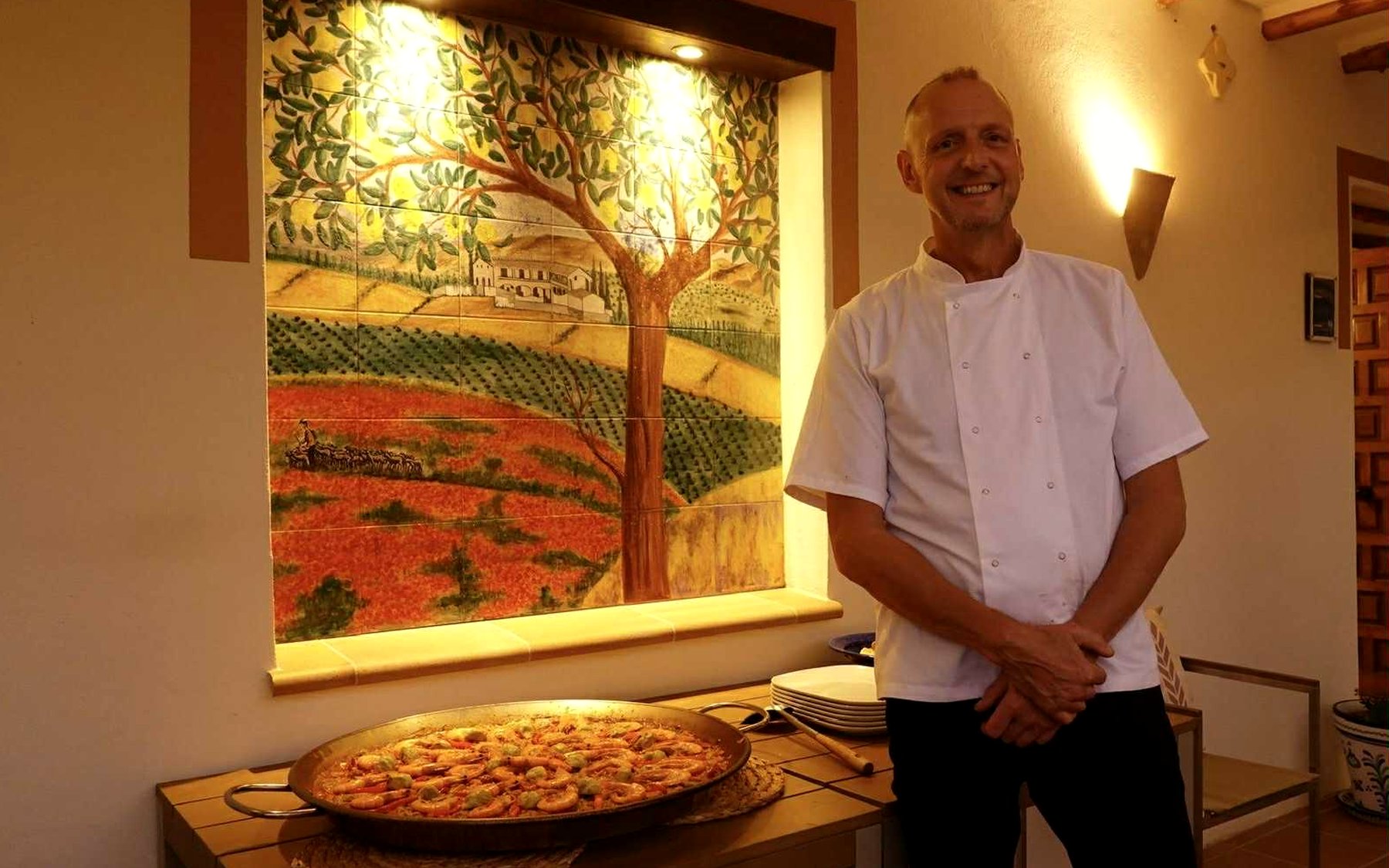 Simon, private chef, beside a seafood paella at a villa in Spain